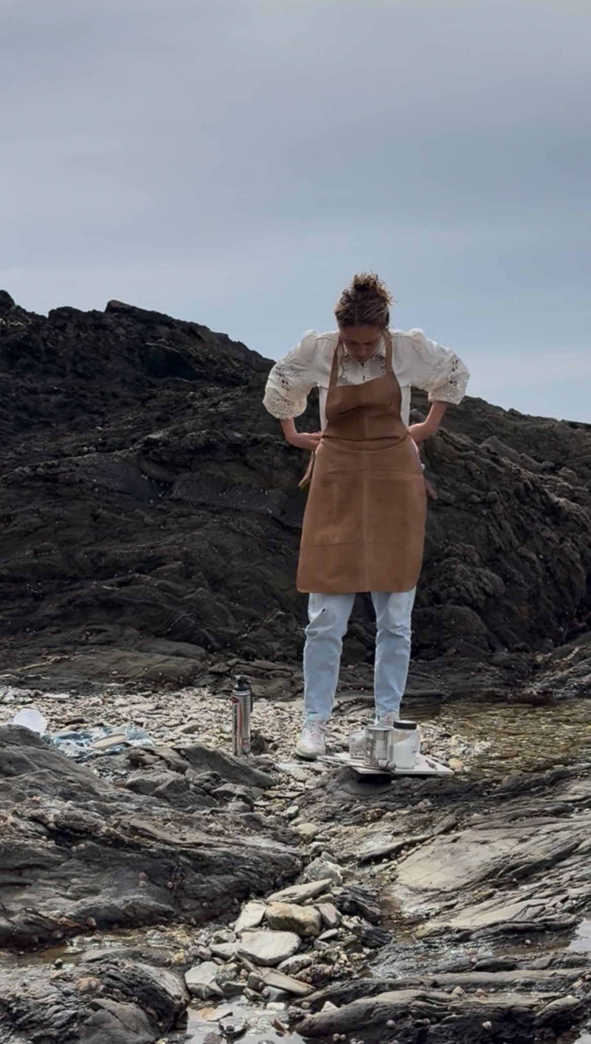 Laura Polley tying a leather apron on the beach Laura Polley tying a leather apron on the beach