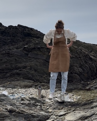 Laura Polley tying a leather apron on the beach Laura Polley tying a leather apron on the beach